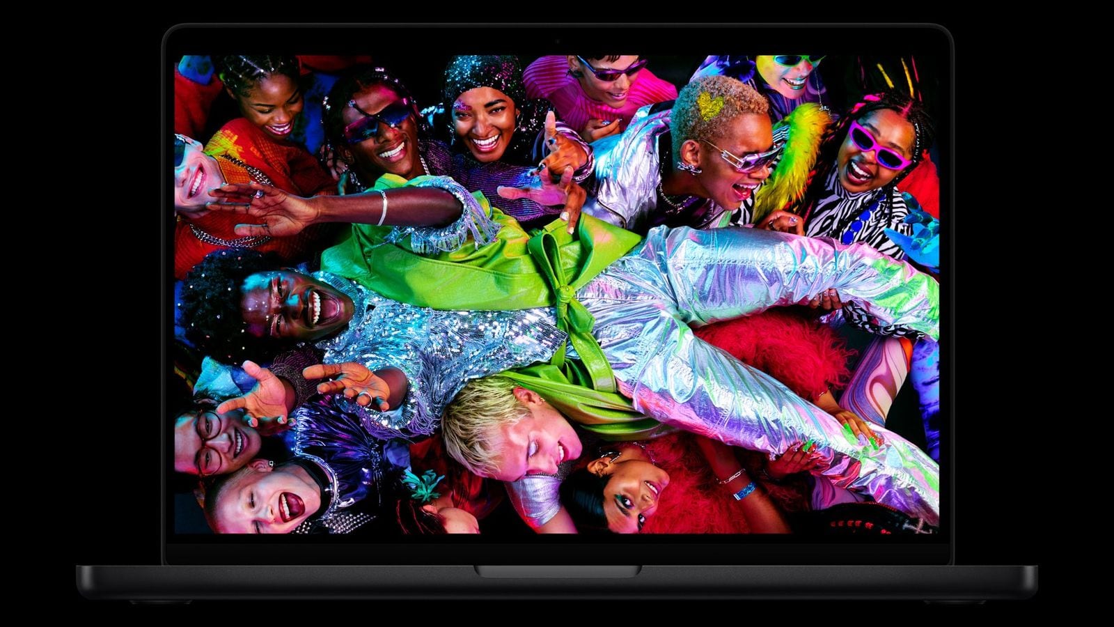 MacBook Pro s farebnou obrazovkou, na ktorej je dav ľudí v pestrom oblečení.