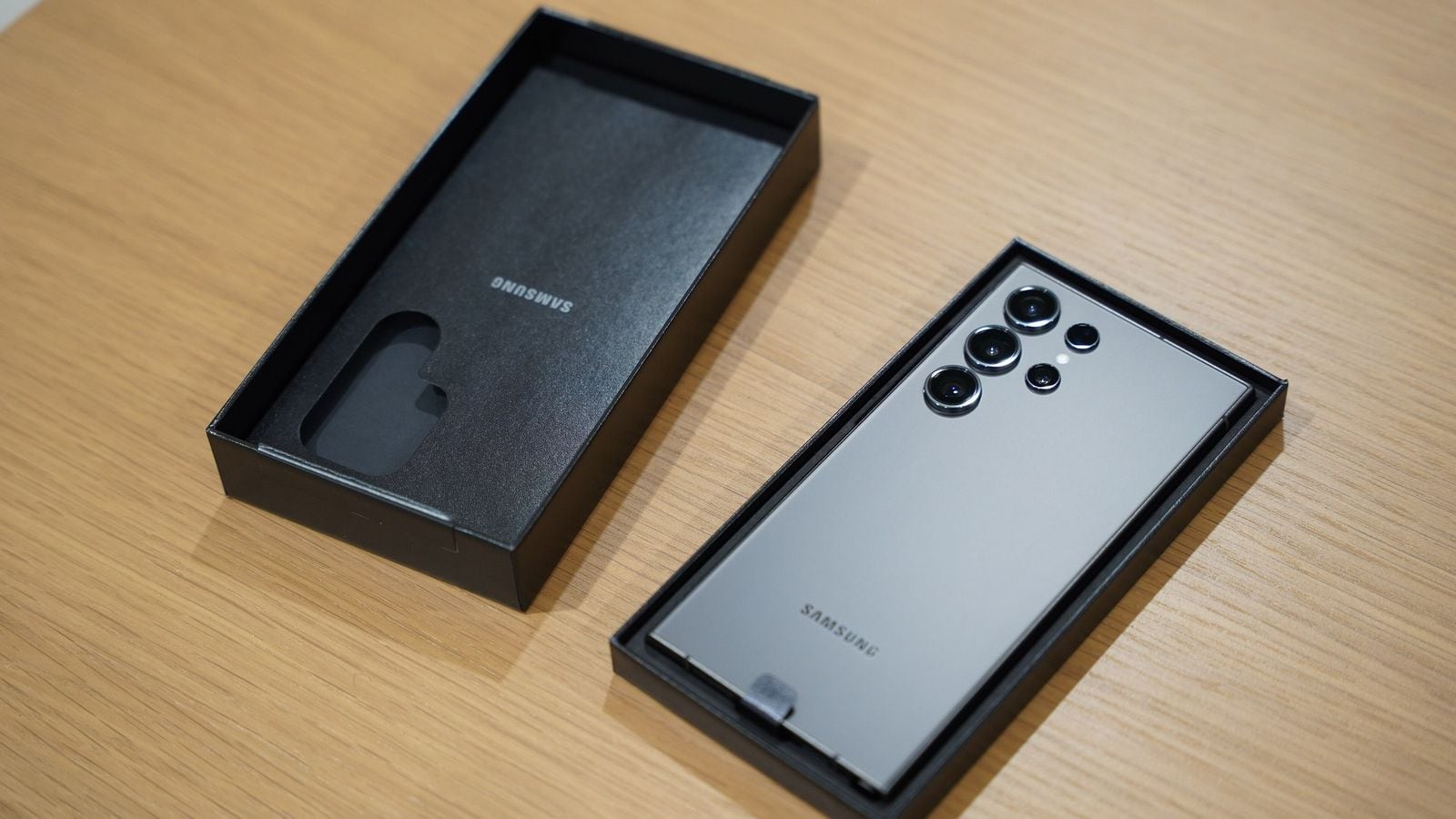 Rozbalený Samsung Galaxy S23 Ultra, viditeľný zadný fotoaparát, strieborno-titánová farba, veko krabice vedľa