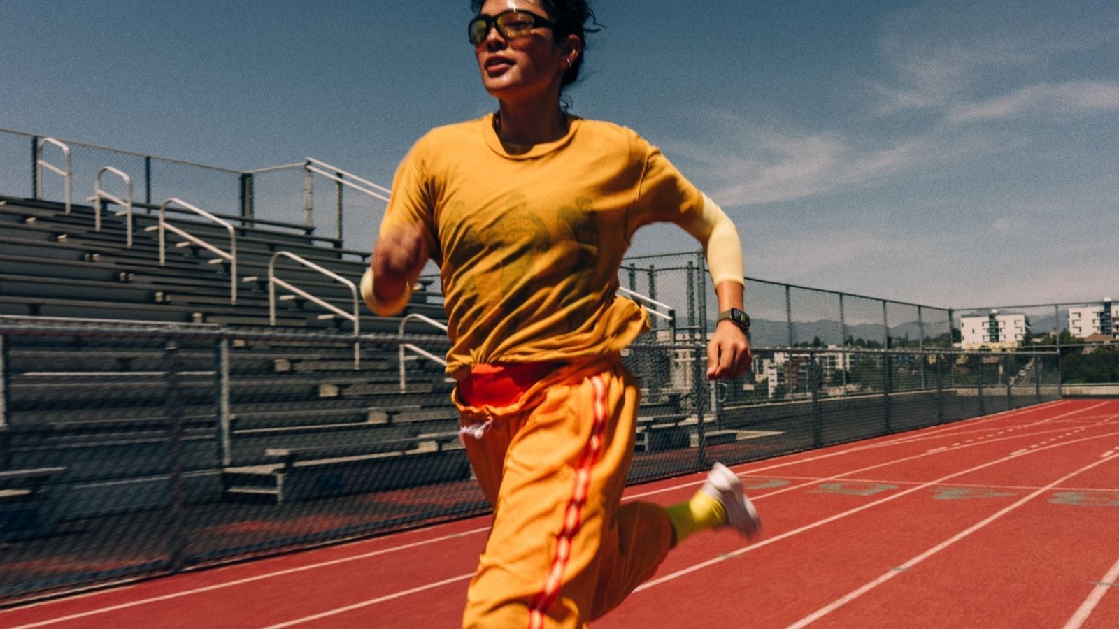 Používateľ Apple Watch Series 12 beží na atletickej dráhe
